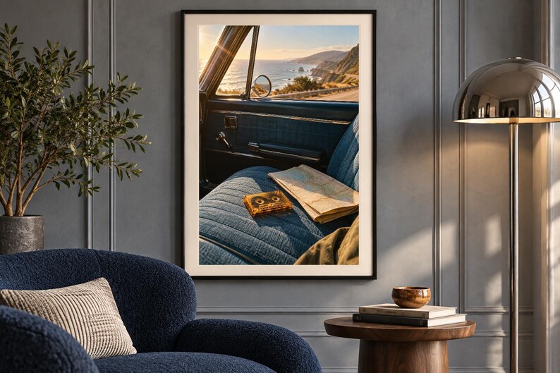 May include: A framed wall art print depicting the interior of a vintage car with blue fabric seats, a cassette tape, and a folded paper map. Through the open window, a coastal highway overlooks the ocean during a golden sunset.
