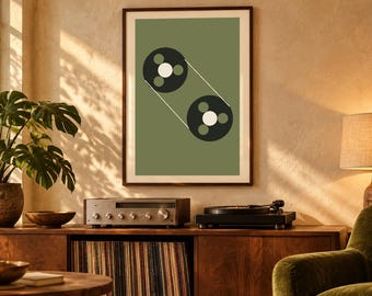 May include: A framed wall art print featuring a sage green background with a graphic illustration of two black circular tape reels connected by thin white lines, each reel containing three small circles in white and green.