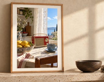 May include: A framed wall art print featuring a kitchen scene with a red radio, a bowl of yellow lemons, and a blue teacup on a table. The view through the window shows a blue sea and cypress trees. The frame is light wood with a white mat border.