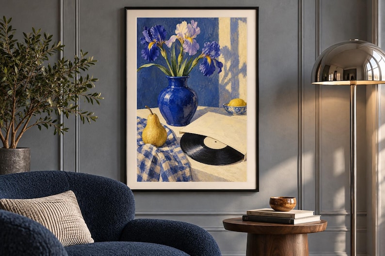 May include: A framed wall art print depicting a still life scene with a blue vase containing purple and white irises, a yellow pear, a black vinyl record in a paper sleeve, and a small bowl with a lemon, all set on a blue and white checkered cloth.