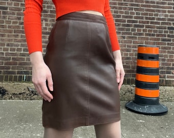 Saia mini vintage em couro marrom, modelo A, da boutique Christian Dior, década de 1960, fabricada na França.