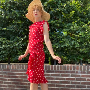Vestido conjunto de lunares en seda roja, blusa con cintura caída y falda cruzada con volantes, estilo retro de los años 70 de OSCAR DE LA RENTA