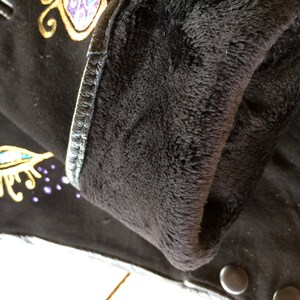 Peut inclure: Gants en cuir noir avec un motif brod&eacute; or et violet. Les gants sont doubl&eacute;s de polaire pour plus de chaleur.