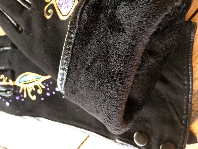 Peut inclure: Gants en cuir noir avec un motif brod&eacute; or et violet. Les gants sont doubl&eacute;s de polaire pour plus de chaleur.