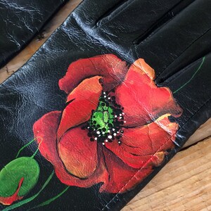 K&ouml;nnte beinhalten: Schwarze Lederhandschuhe mit handbemaltem rotem Mohnblumenmuster.