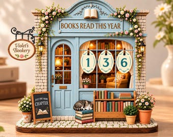 May include: A miniature bookstore model featuring a light blue facade, a hanging sign reading Violet's Bookery, and a chalkboard sign saying Just One More Chapter. The display shows the text Books Read This Year above three oval number signs 1, 3, 6.