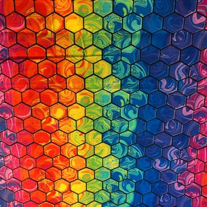 K&ouml;nnte beinhalten: Ein lebendiger, farbenfroher Stoff mit einem Wabenmuster. Das Design zeigt einen Regenbogen aus Farben, darunter Rot, Orange, Gelb, Gr&uuml;n, Blau und Lila, mit einem Marmoreffekt in jedem Sechseck. Die schwarzen Umrisse der Sechsecke erzeugen einen auff&auml;lligen Kontrast.