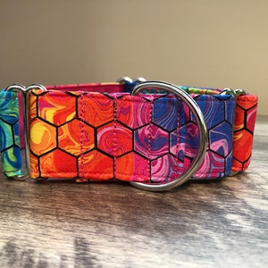 K&ouml;nnte beinhalten: Ein farbenfrohes Hundehalsband mit einem lebendigen, sechseckigen Muster in Orange, Pink, Blau und Gr&uuml;n. Das Halsband verf&uuml;gt &uuml;ber einen stabilen Metall-D-Ring und Beschl&auml;ge f&uuml;r den Leinenanschluss. Das Halsband ist auf Langlebigkeit und Stil ausgelegt.