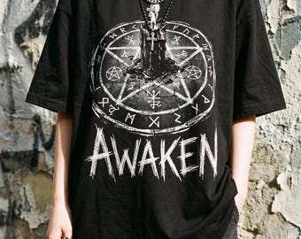 Halloween PNG met mystieke kaars, occulte symbolen en verweerde AWAKEN-letters.