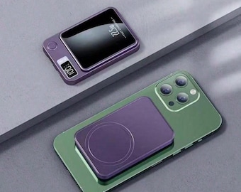 Puede incluir: Una batería externa portátil morada con una pantalla digital que muestra 100% y el texto 22.5W fast charging, junto a un smartphone verde con una batería magnética inalámbrica morada acoplada en la parte posterior del dispositivo.