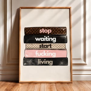 May include: A framed wall art print featuring a stack of five books with designer-inspired patterns. The spines display the text: stop, waiting, start, fucking, living. The books are colored in brown, black, beige, and light pink tones.
