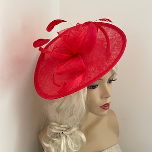 Tocado de estilo platillo rojo con plumas en la diadema, perfecto para las carreras de Ascot o una boda.