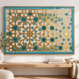 Puede incluir: Una pieza de arte mural rectangular con un complejo patrón de mosaico geométrico. El diseño consiste en formas de estrellas entrelazadas y azulejos detallados en tonos azul verdoso, blanco y oro metálico, dentro de un marco dorado fino.