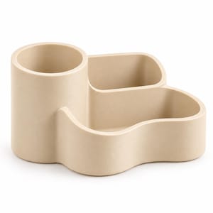 May include: A beige desk organizer featuring a tall cylindrical compartment on the left side and two lower, interconnected sections with curved, organic-shaped walls on the right side. The entire unit has a smooth, matte finish and solid construction.
