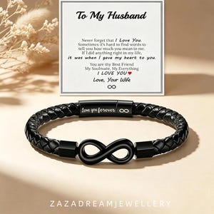 Op de afbeelding: Een zwarte gevlochten leren armband met een centraal oneindigheidssymbool en een metalen sluiting gegraveerd met de tekst "love you forever" en een oneindigheidsteken, vergezeld van een kaart met de tekst "To My Husband" en romantische tekst.
