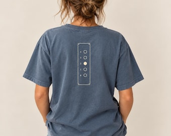 May include: A slate blue short-sleeve t-shirt featuring a rectangular graphic on the back. The graphic contains a vertical column of five circles labelled 4, 3, 2, 1, and 0, with the circle next to the number 2 filled in with a solid cream colour.
