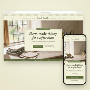 Könnte beinhalten: Eine Website-Oberfläche für Fern & Thimble, dargestellt auf einem Desktop-Monitor und einem Mobiltelefon. Die Seite zeigt den Text Slow-made things for a softer home, Navigationsmenüs sowie ein Foto von Leinen und Stickrahmen.