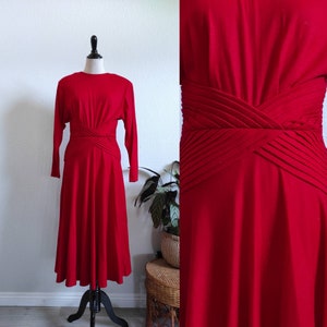 Puede incluir: Un vestido rojo midi con mangas largas y un detalle plisado en la cintura.