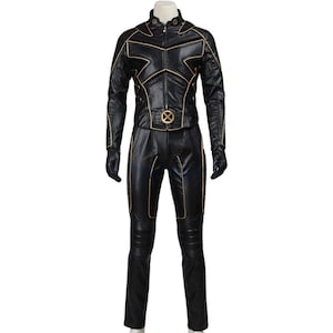 May include: A black leather-like jumpsuit featuring long sleeves, a high collar, and gold piping accents. The jacket includes a central zipper and a circular gold emblem at the waist. The pants have reinforced knee sections and matching gold trim.