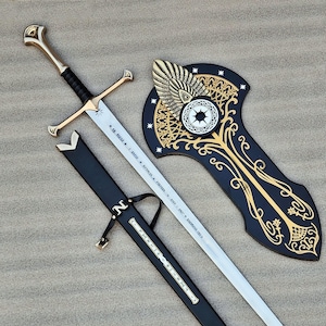May include: A metal sword with a gold-toned hilt and black grip, featuring an engraved blade with runic text. It is accompanied by a black scabbard with a silver-toned letter N and a black wall plaque decorated with gold filigree and stars.