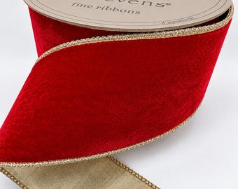 May include: A spool of d.stevens fine ribbons featuring a wide, deep red velvet ribbon with a metallic gold wired edge. The spool label is beige with gold decorative flourishes and the text d.stevens fine ribbons. The underside of the ribbon is a muted gold fabric.