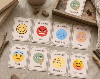 Può includere: Un set di carte rettangolari con vari volti in stile emoji che rappresentano emozioni. Ogni carta mostra il testo 'Ik voel me' sopra un'illustrazione di un volto e una parola corrispondente all'emozione in olandese, come Blij, Boos, Verdrietig o Moe.