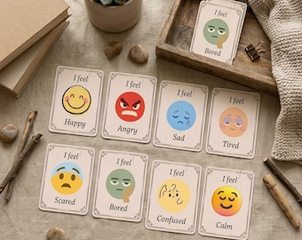 Può includere: Un set di carte rettangolari con illustrazioni di varie espressioni facciali con il testo I feel seguito dal nome dell'emozione, tra cui Happy, Angry, Sad, Tired, Scared, Bored, Confused e Calm, stampate su cartoncino color crema.