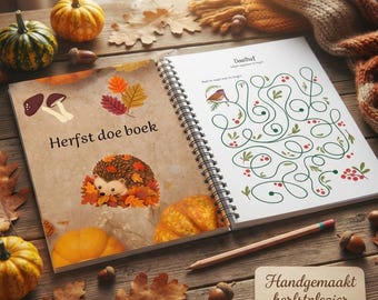 Può includere: Un libro di attività a spirale intitolato Herfst doe boek con illustrazioni di funghi, foglie autunnali e un riccio. La pagina destra mostra un labirinto con un uccellino e bacche. Un cartello in legno riporta la scritta Handgemaakt herfstplezier.