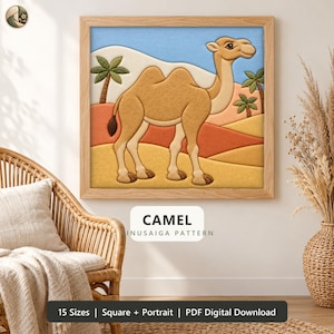 May include: A square framed wall art piece featuring a tan camel standing in a desert landscape with rolling orange and yellow dunes, green palm trees, and a light blue sky. The text CAMEL MINUSAIGA PATTERN is printed below the image.