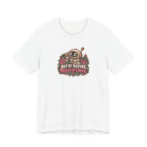 May include: A white short-sleeved t-shirt featuring a central graphic of a cartoon robot surrounded by pink roses and green leaves. The text "BOT BY NATURE" and "MENACE BY CHOICE" is printed in a stylised font below the robot illustration.