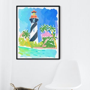 May include: Watercolor art print of a lighthouse with black and white stripes, a red top, and a blue sky background. Palm trees and a turquoise sea are in the foreground. The artwork is framed in a black frame.