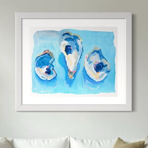 May include: A framed painting of three oyster shells on a light blue background. The shells are painted in shades of blue, white, and gold. The painting is signed "Sweet H" in the bottom left corner.