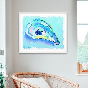 May include: Abstract painting of an oyster shell in shades of blue, green, pink, and yellow on a light blue background. The painting is framed in white and has the artist's signature "Broch" in the bottom left corner.