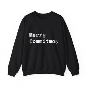 Op de afbeelding: Een zwart sweatshirt met lange mouwen en een ronde hals, voorzien van de witte tekst Merry Commitmas op de voorzijde. Het kledingstuk heeft een geribbelde kraag, boorden en zoom, met een standaard pasvorm en een effen zwarte stof.