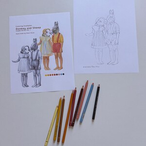 May include: Two sheets of paper featuring line art of a child with a sheep head and a child with a donkey head. One sheet shows colored examples with the text Coloring Examples Donkey and Sheep Couple Series Vol. 1. Eight colored pencils are arranged below.
