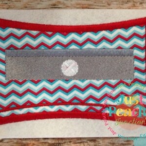 Op de afbeelding: Een rode en witte chevron-stofzak met een grijze klep van stof en een witte knoop. De zak is omgeven door een rode rand.
