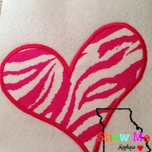 May include: A pink and white zebra print heart-shaped embroidery design. The design is outlined in red thread.