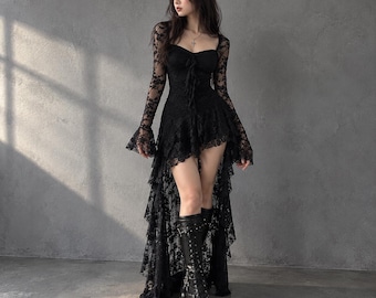 May include: A black long-sleeved dress featuring intricate lace detailing, a sweetheart neckline, and a high-low hemline with tiered ruffles. The garment is paired with black platform lace-up boots that reach mid-calf.