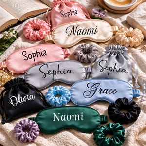 May include: A collection of satin sleep masks and matching drawstring pouches and scrunchies in various colors including pink, champagne, silver, blue, black, and green, each personalized with names like Sophia, Naomi, Olivia, and Grace.
