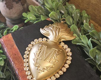 Flaming Heart encircled by clear rhinestone gems and delicate metal applique of vine and M monogram with loop for hanging 5 by 3 inches