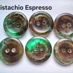Puede incluir: Seis botones redondos con dos agujeros cada uno, que presentan una mezcla arremolinada de colores verde transl&uacute;cido y marr&oacute;n oscuro. El texto 'Pistachio Espresso' est&aacute; impreso en negro sobre los botones, que tienen un acabado liso, brillante y semitransparente.