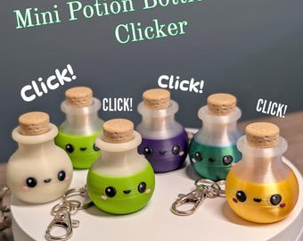 May include: Six mini potion bottle fidget clickers with cork stoppers and metal keychains. Each bottle features a cute face with black eyes and pink cheeks, in colors including white, lime green, purple, teal, and yellow. Text reads Mini Potion Bottle Fidget Clicker and Click!