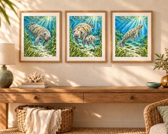 May include: Three framed wall art prints featuring manatees swimming in clear blue water with sunlight rays filtering from above. The artwork depicts manatees in a natural underwater environment with green seagrass and sandy ocean floors.