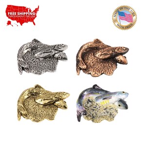 May include: Four different colored metal fish pins. The fish are silver, gold, copper, and a mottled gray and white. Each pin features two fish, one on top of the other, with the top fish's mouth open as if it is eating the fish below. The fish are on a textured base that looks like a rock or a piece of coral.