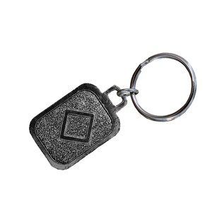 May include: Silver key chain with a square design in the center of the tag.