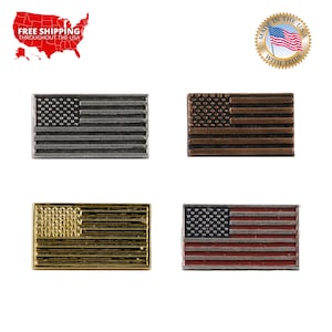 May include: Four small American flag lapel pins in different finishes: silver, copper, gold, and red, white, and blue.  The pins are all the same size and shape, and they are all made of metal.