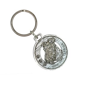 May include: Silver-toned keychain featuring a wirehaired terrier dog head in profile. The keychain has a round tag with the words "Wirehaired Terrier" and "Terrier" inscribed around the dog's head.