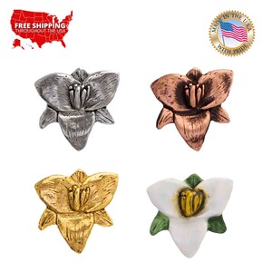 May include: Four flower-shaped metal charms in different colors: silver, copper, gold, and white with green leaves. The charms are about 1 inch in diameter.