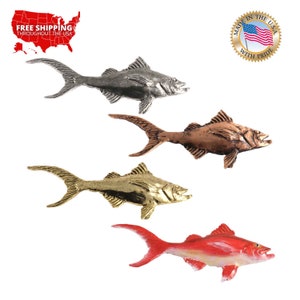 Pode incluir: Quatro figurinhas de peixe de metal em diferentes cores: prata, cobre, ouro e vermelho. Os peixes estão todos olhando para o lado direito da imagem e têm um design semelhante. Os peixes são feitos nos Estados Unidos com orgulho.