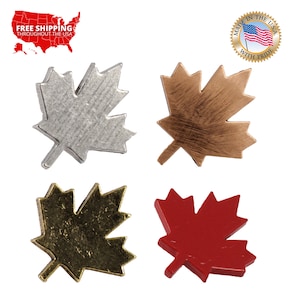 May include: Four maple leaf shaped metal charms in different colors: silver, copper, gold, and red.